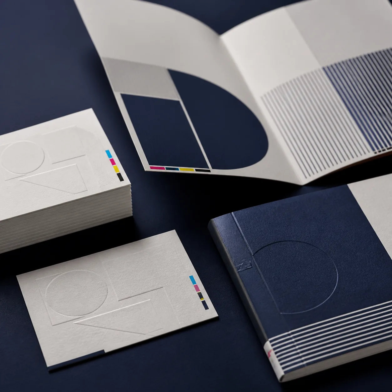 Premium business cards, a folded brochure and a bound booklet showing fine paper and finishing details.